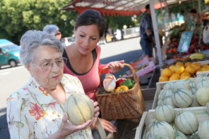 caregiver assisting the old woman to buy vegetables