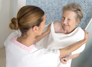 caregiver giving towel to the old woman